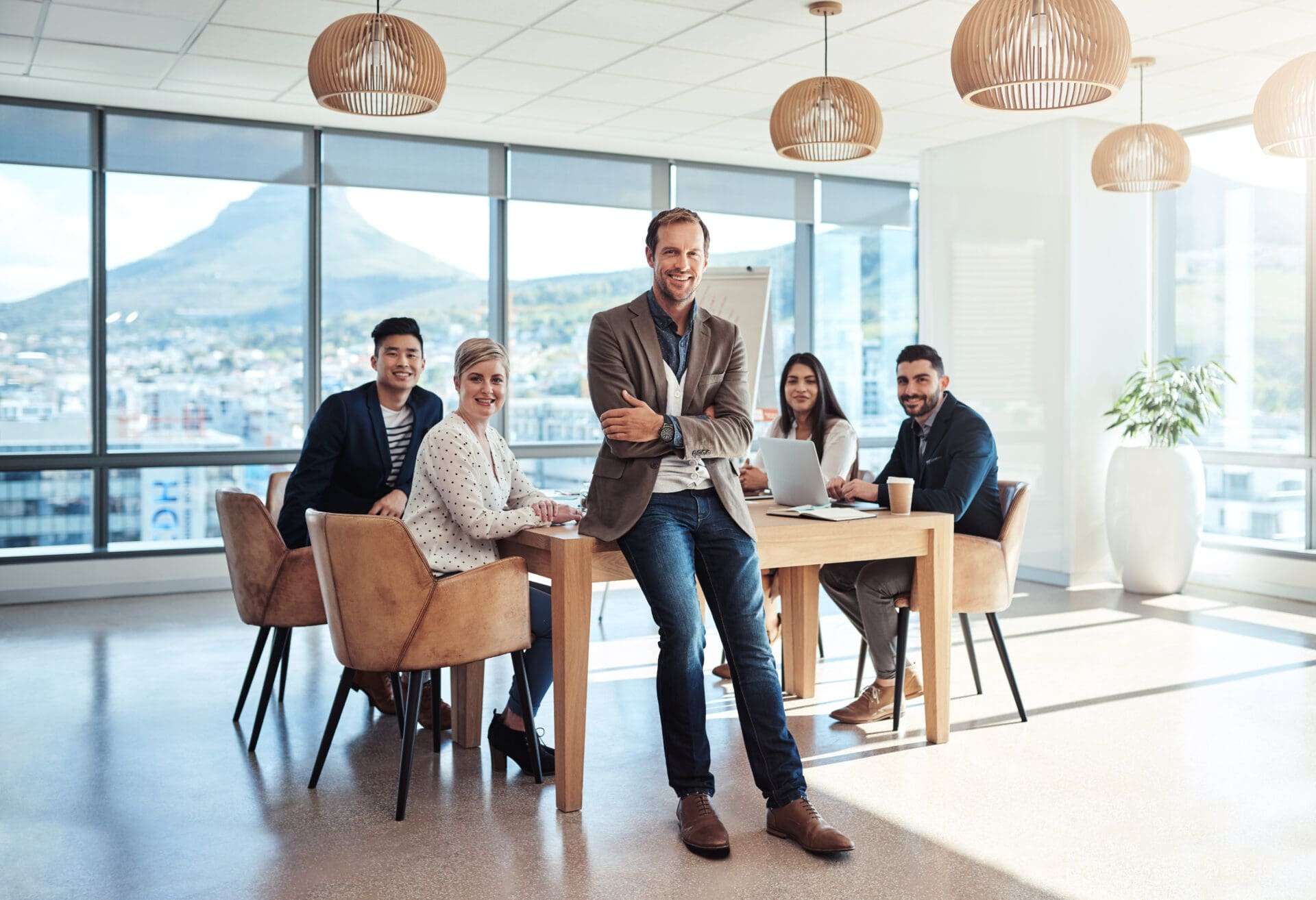 5 ceos around a wooden desk smiling